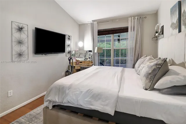 a bedroom with a bed and a flat tv screen on dresser