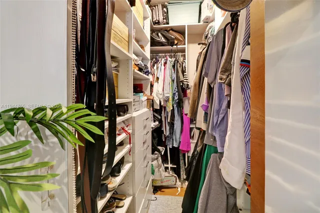 a view of walk in closet with clothes