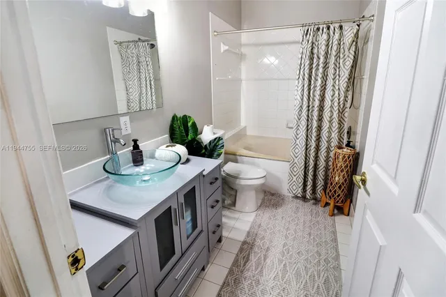 a bathroom with a sink a toilet and shower curtain
