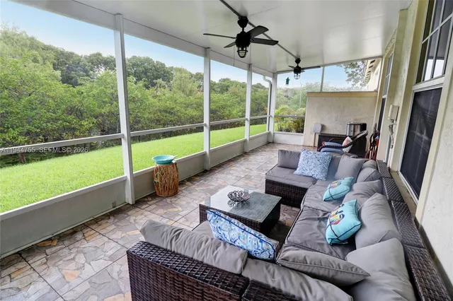 a living room with furniture and a floor to ceiling window
