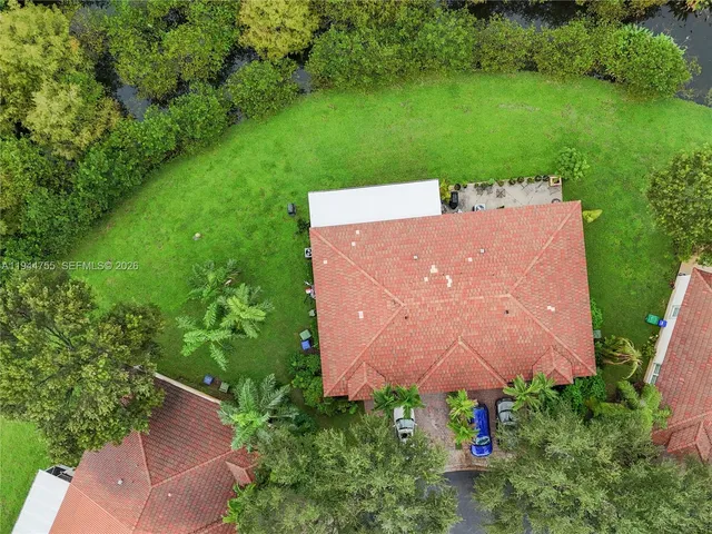an aerial view of a house with a yard and lake view