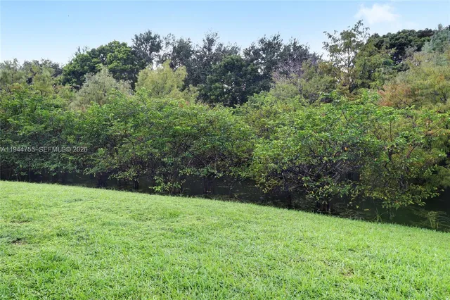 a view of green field with trees in the background
