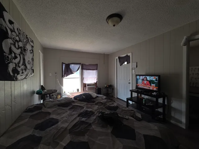 a bedroom with a bed and a dresser next to a window