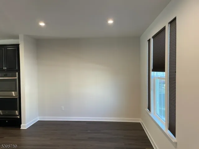 a kitchen with stainless steel appliances a kitchen island hardwood floor sink stove and wooden cabinets