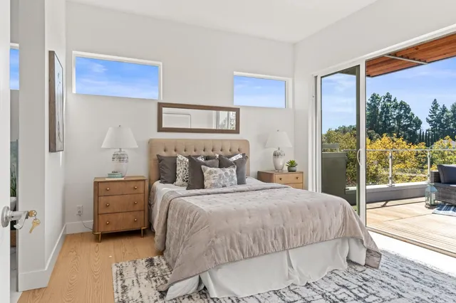a bedroom with a bed and large windows