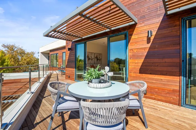 a patio with a table and chairs and wooden floor
