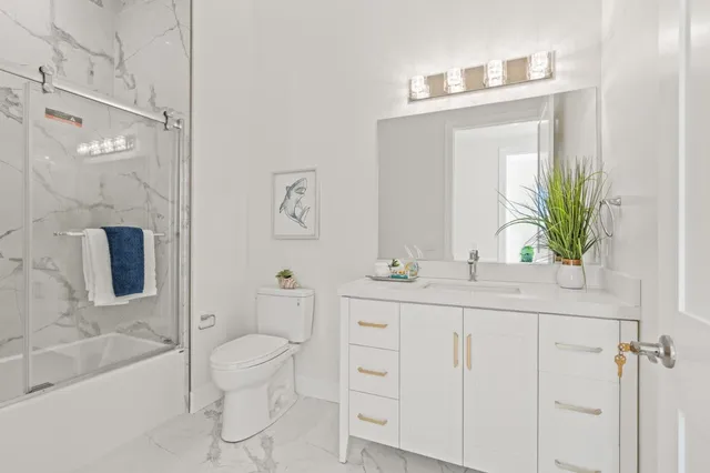 a bathroom with a sink a toilet and shower