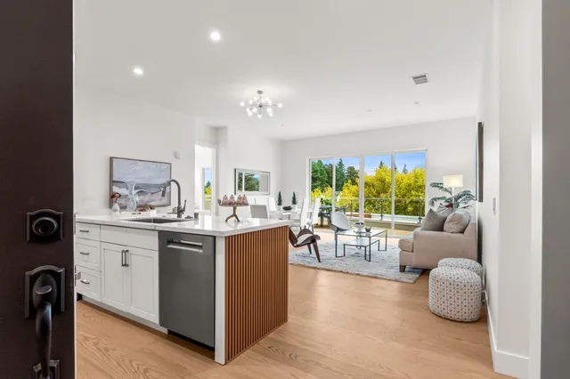 a view of living room kitchen with stainless steel appliances granite countertop furniture and a fireplace