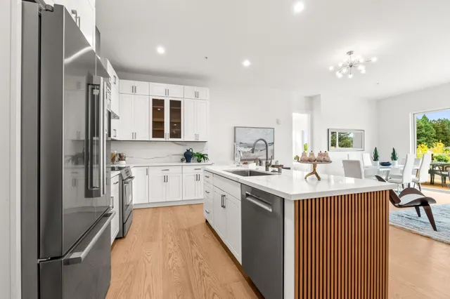 a large kitchen with kitchen island a sink a counter space and stainless steel appliances