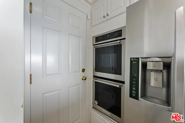 a view of kitchen with stainless steel appliances granite countertop a stove and a wooden floors