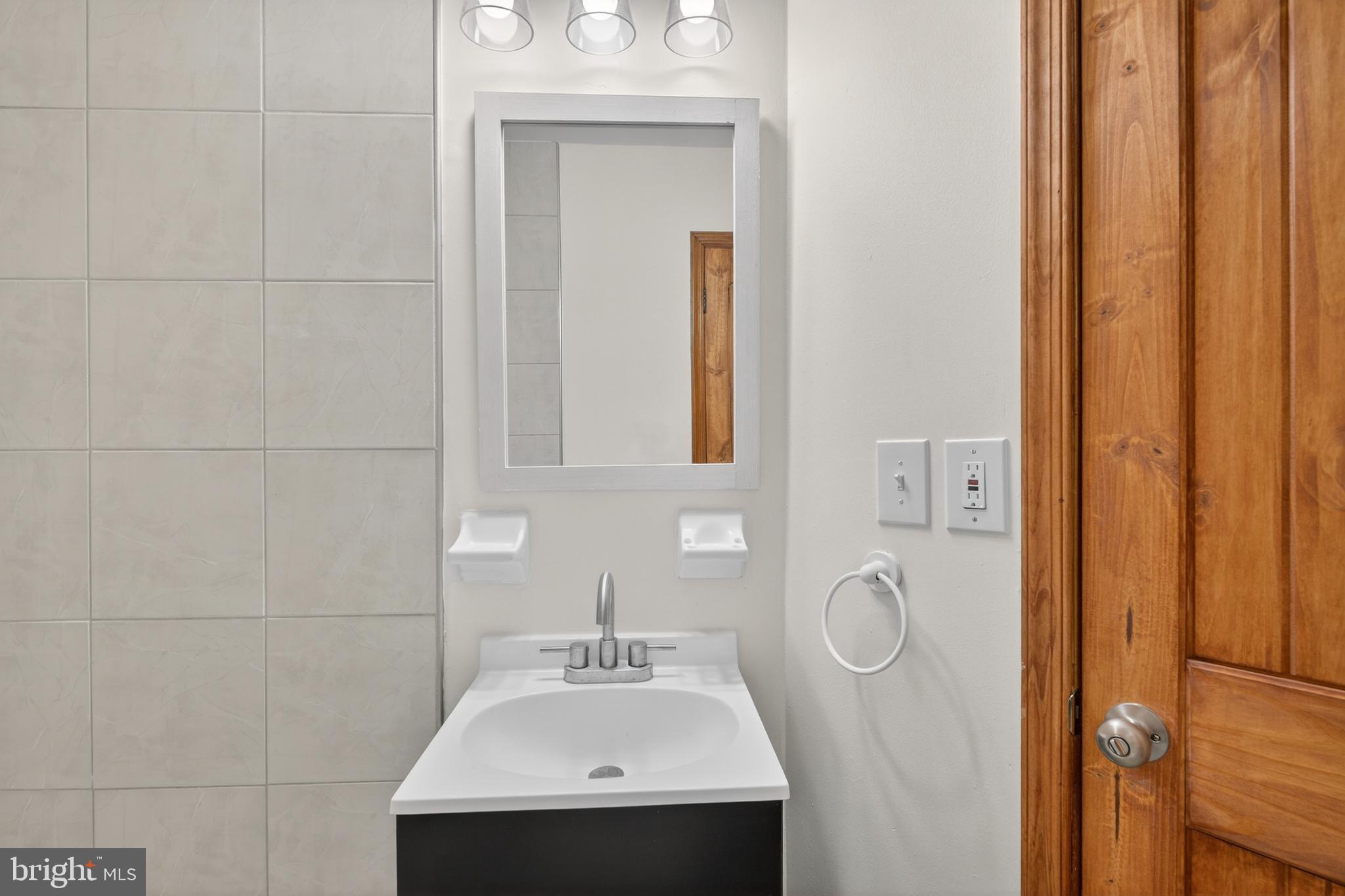 4037 1st Street Chesapeake Beach, MD 20732 - Photo 11 of 26 a bathroom with a sink a mirror and vanity