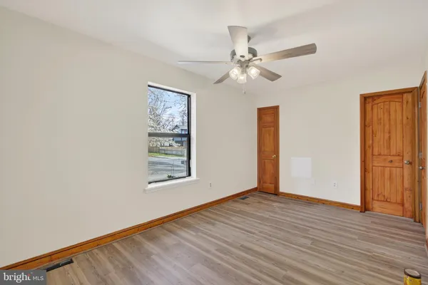 a view of an empty room with wooden floor