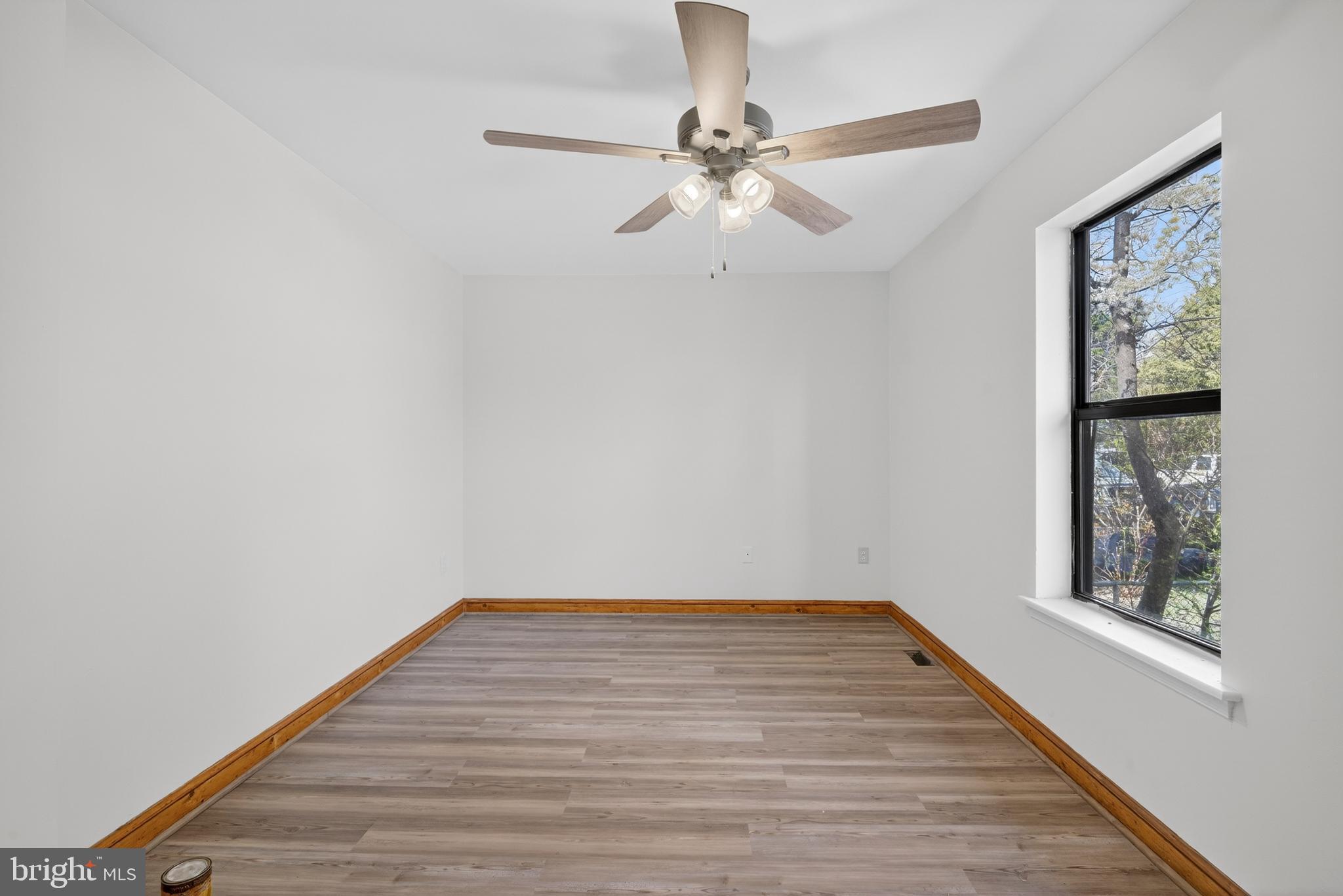 4037 1st Street Chesapeake Beach, MD 20732 - Photo 17 of 26 a view of an empty room with wooden floor and a window