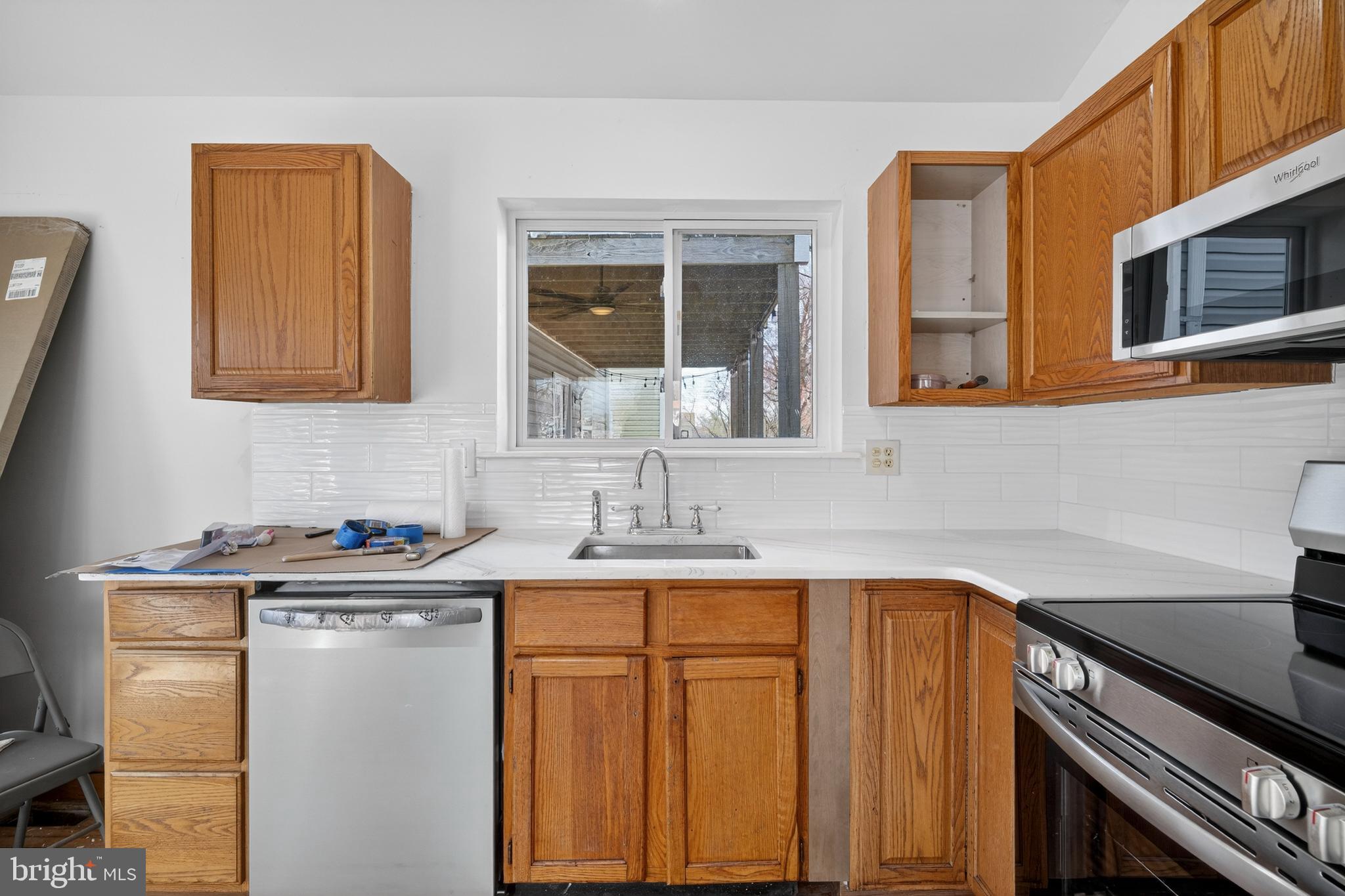 4037 1st Street Chesapeake Beach, MD 20732 - Photo 3 of 26 a kitchen with stainless steel appliances granite countertop a sink stove and cabinets
