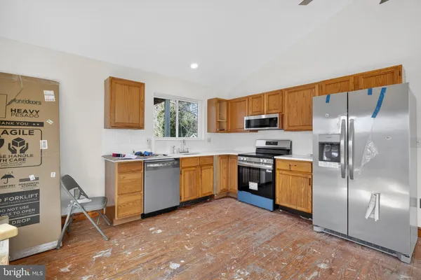 a kitchen with stainless steel appliances granite countertop a stove a sink and a refrigerator