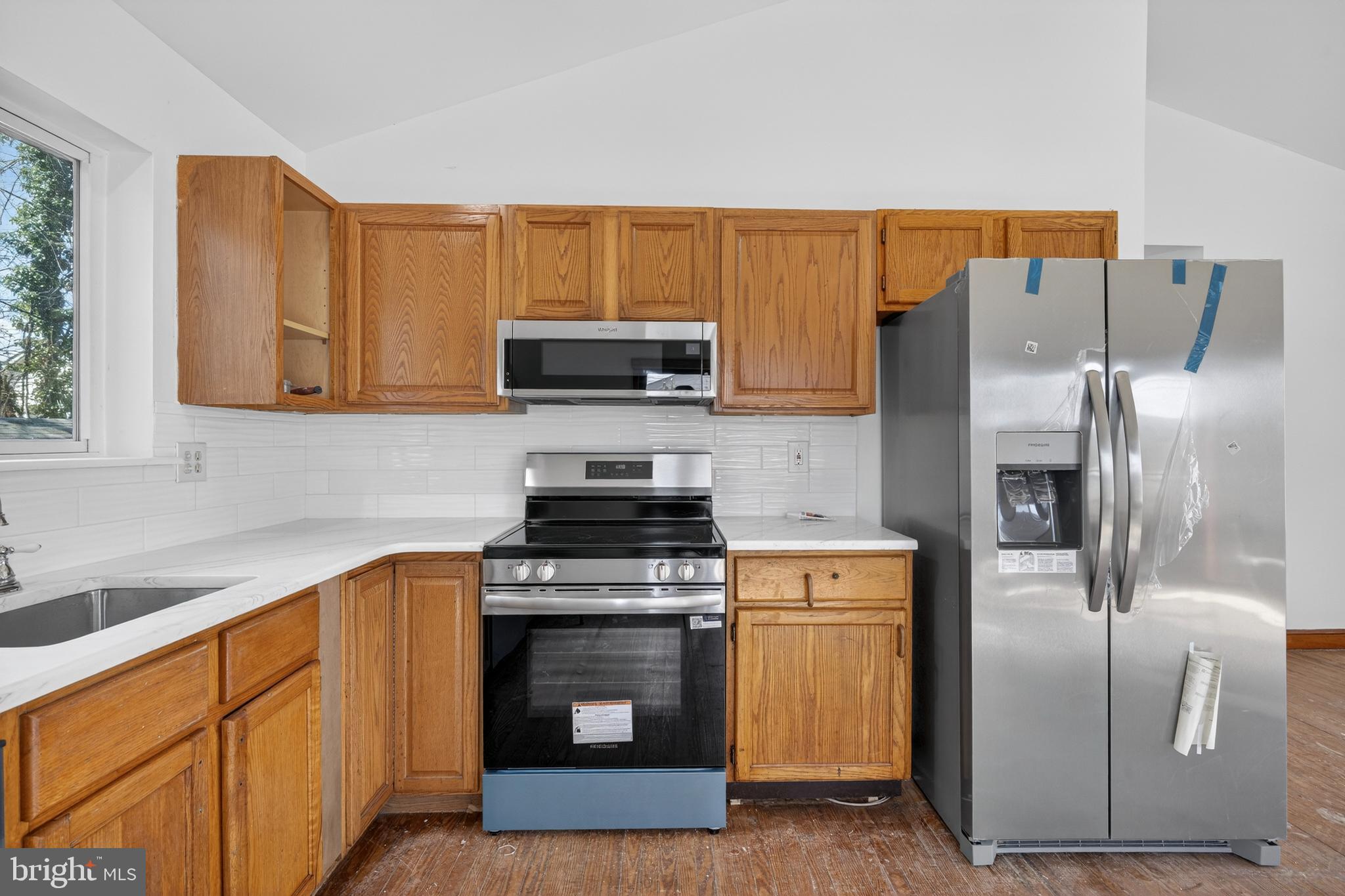 4037 1st Street Chesapeake Beach, MD 20732 - Photo 5 of 26 a kitchen with stainless steel appliances granite countertop a stove a sink and a refrigerator