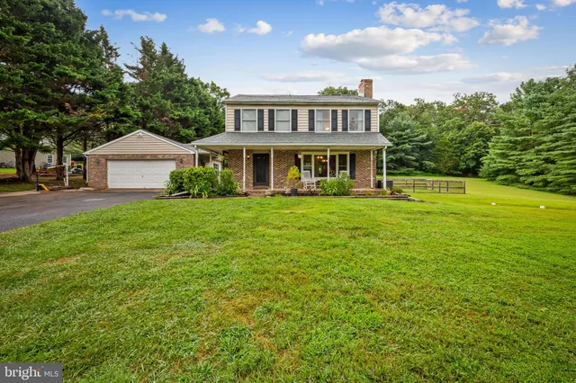 a view of a house with a big yard and large trees