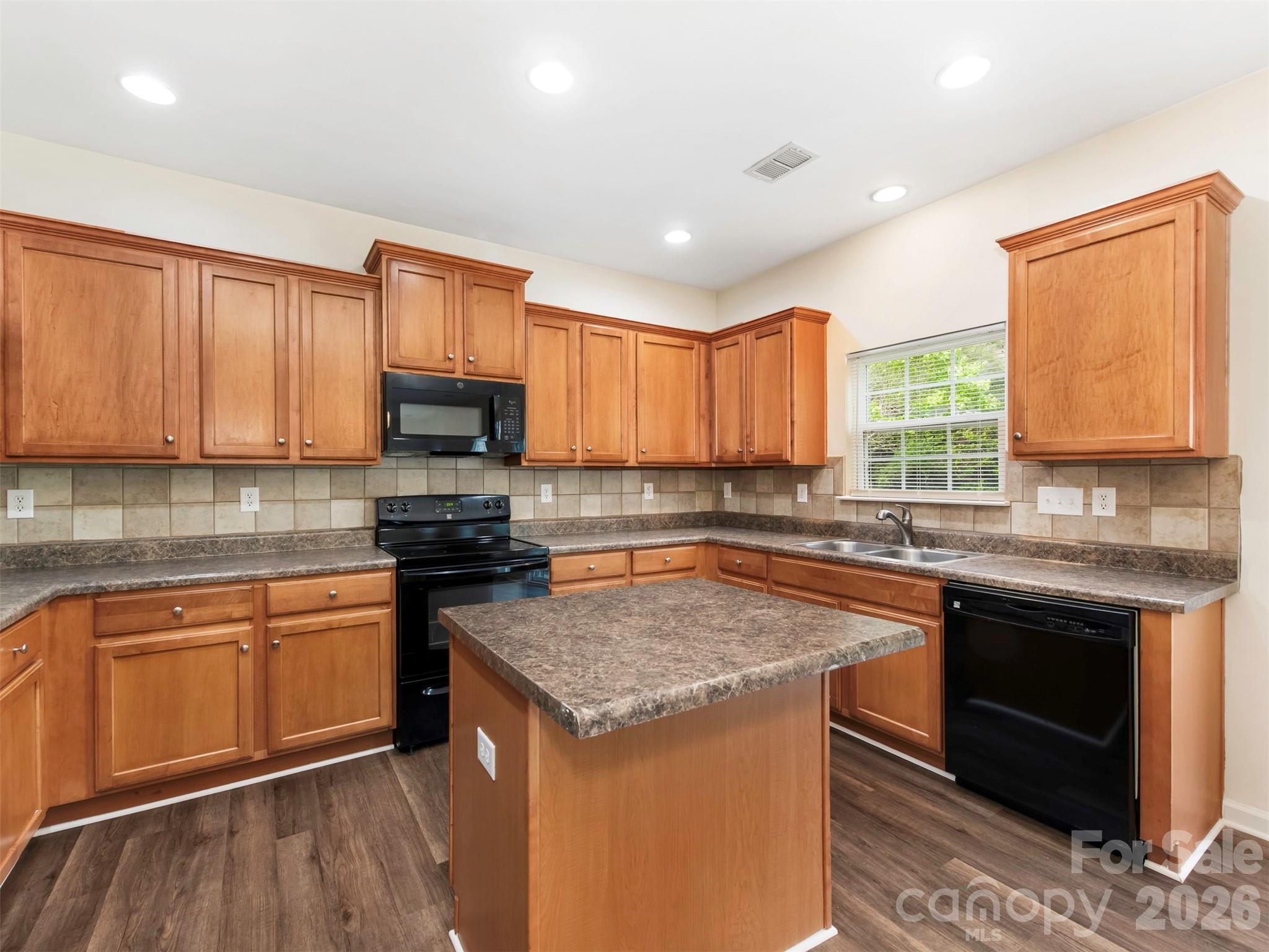 6507 Hermsley Road Charlotte, NC 28278 - Photo 33 of 40 a kitchen with stainless steel appliances granite countertop a stove a sink and a microwave