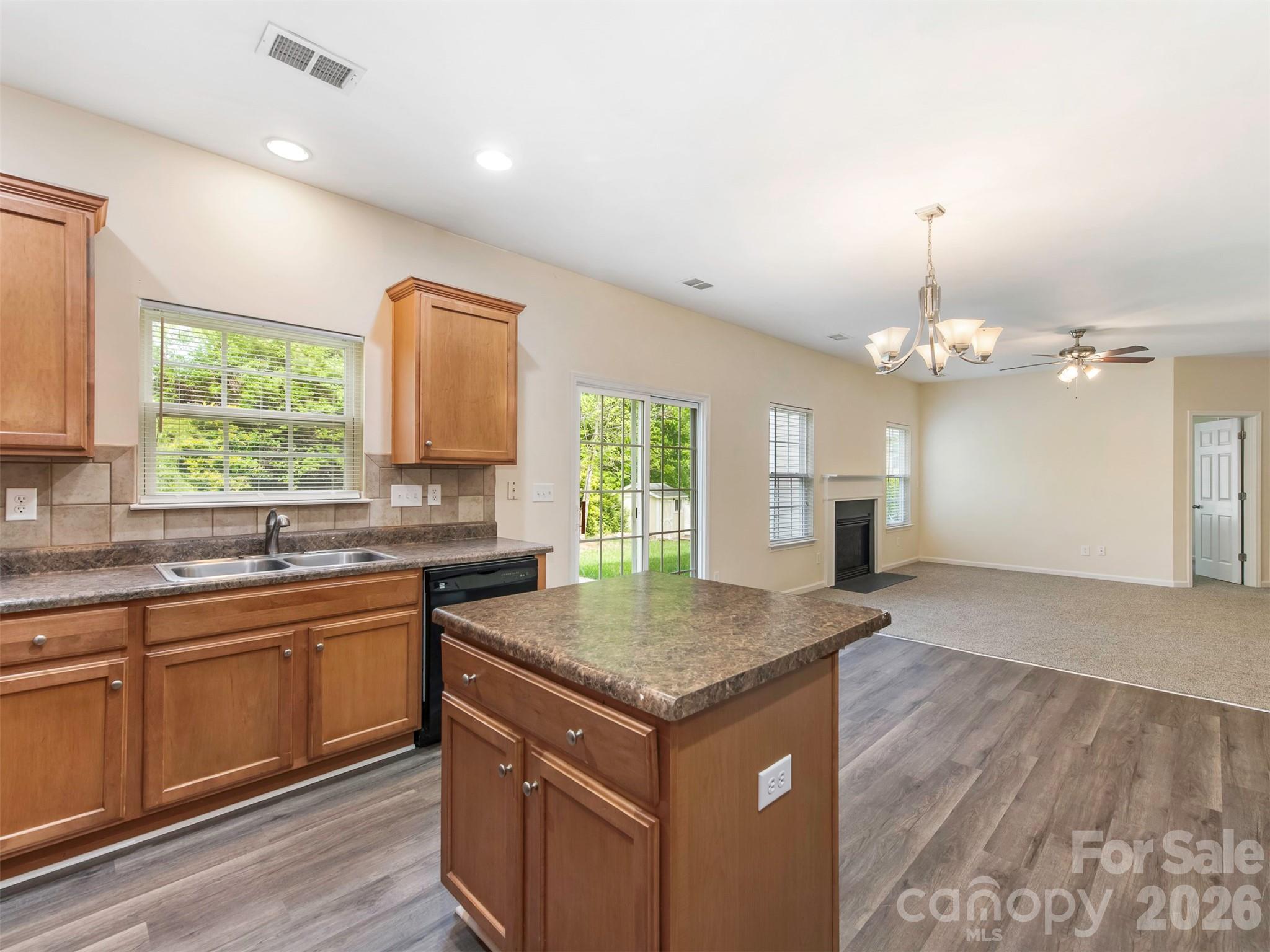 6507 Hermsley Road Charlotte, NC 28278 - Photo 34 of 40 a kitchen that has a sink a microwave oven a dining table and chairs with wooden floor