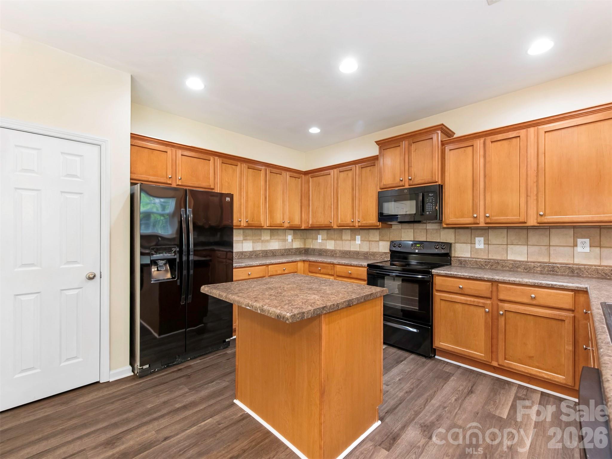 6507 Hermsley Road Charlotte, NC 28278 - Photo 35 of 40 a kitchen with stainless steel appliances granite countertop a stove top oven a sink dishwasher a refrigerator and a microwave oven with wooden floor