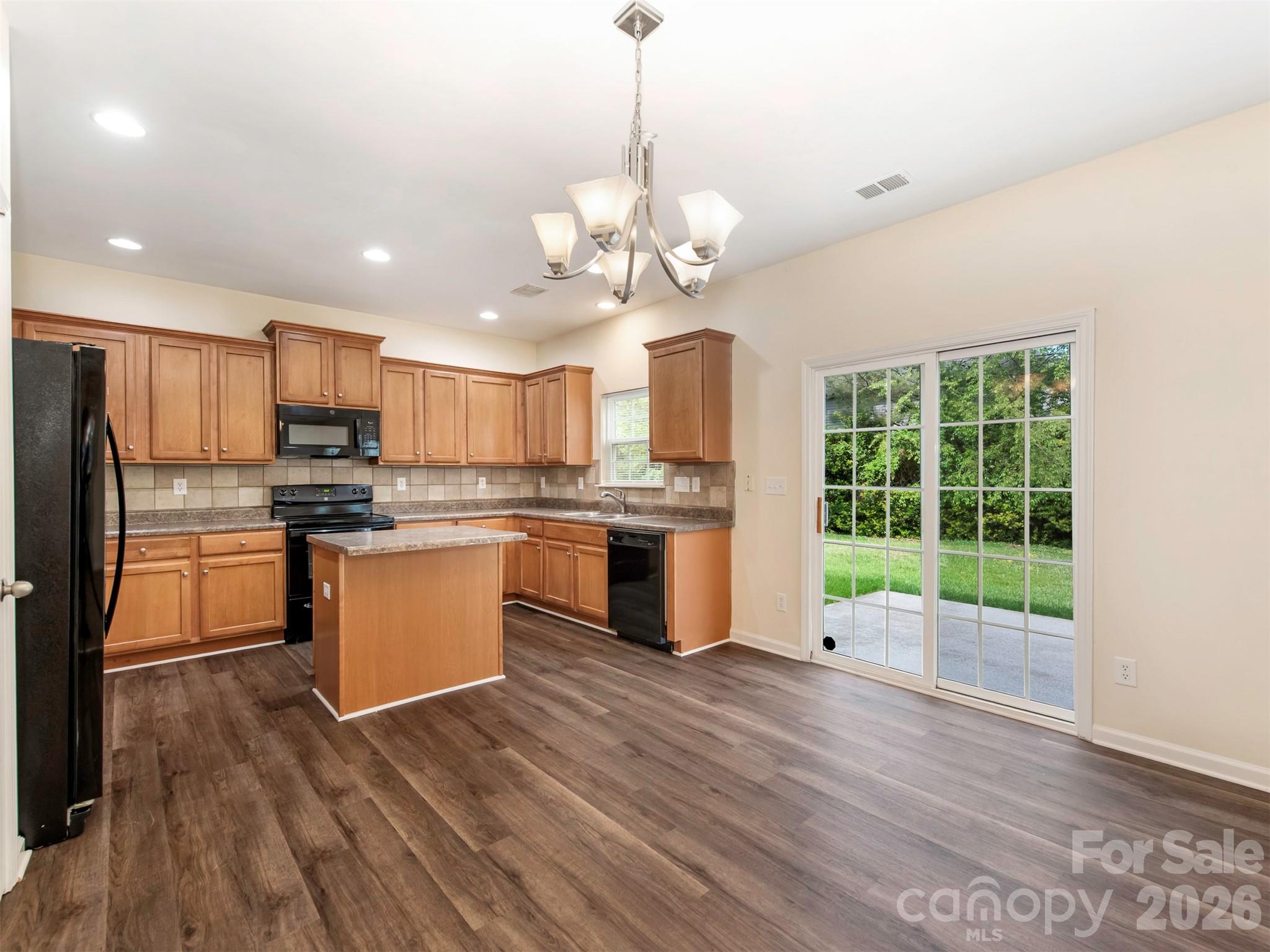 6507 Hermsley Road Charlotte, NC 28278 - Photo 10 of 40 a kitchen with stainless steel appliances granite countertop a refrigerator a sink dishwasher a stove and white countertops with wooden floor
