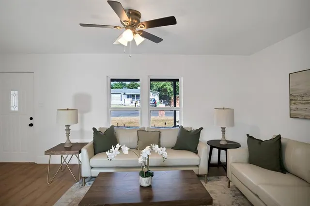 a living room with furniture kitchen view and a window