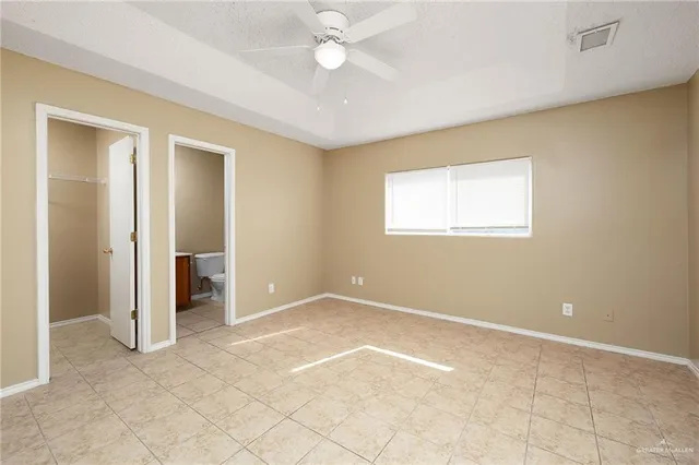 an empty room with a ceiling fan and a window