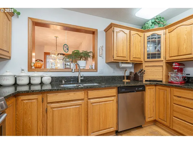 a kitchen with granite countertop a sink a counter top space and cabinets