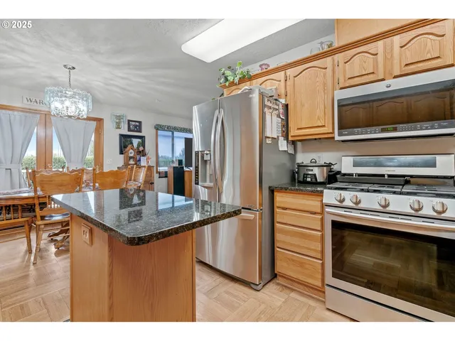 a kitchen with stainless steel appliances granite countertop a stove refrigerator and microwave
