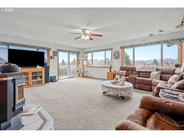 a living room with furniture a flat screen tv and a large window