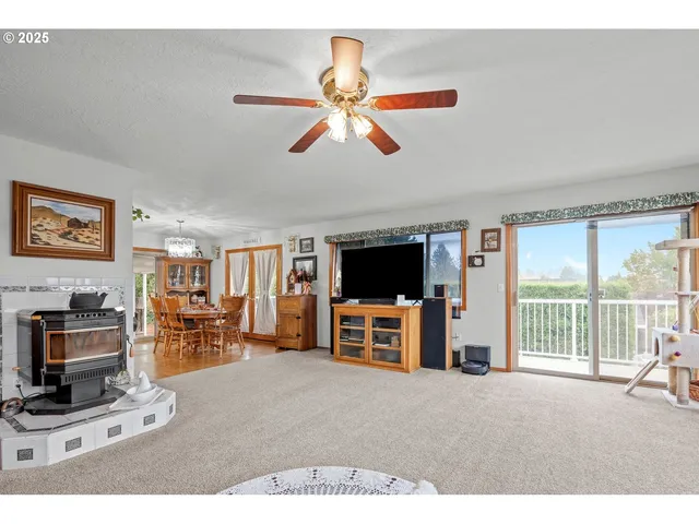 a view of a livingroom with furniture flat screen tv wooden floor and a ceiling fan