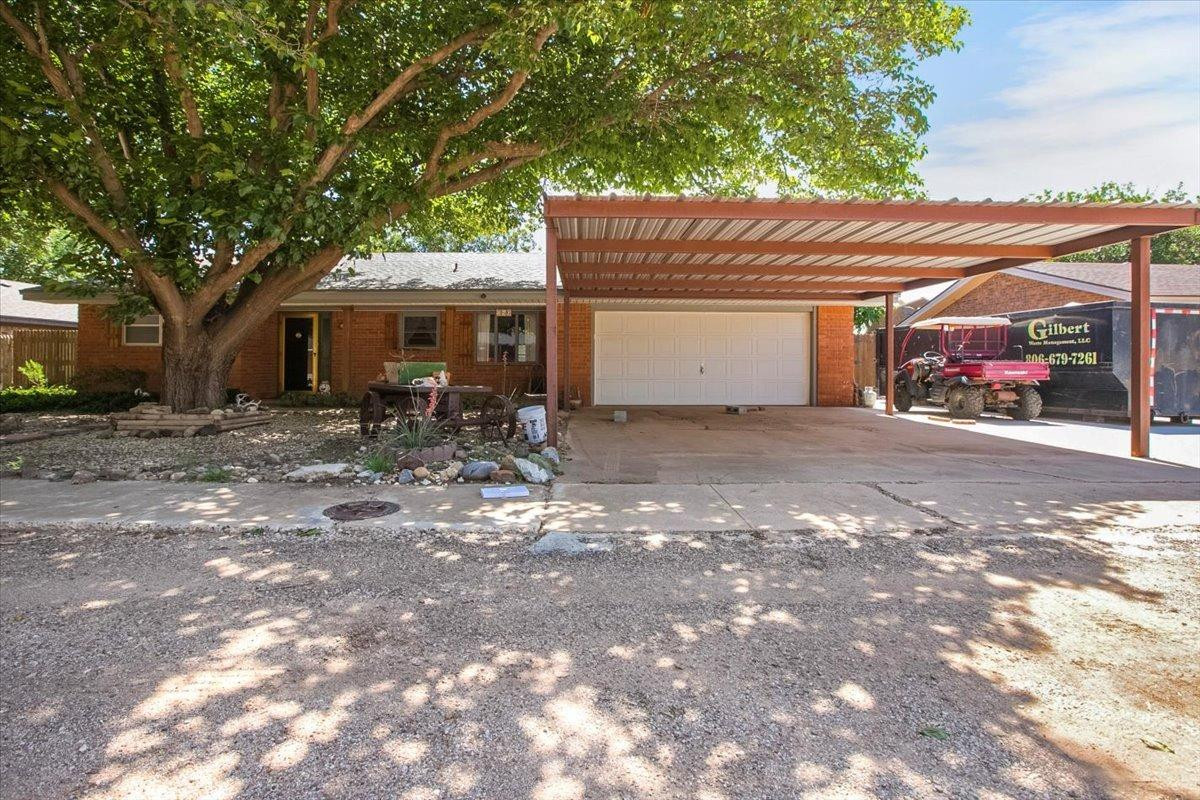 a backyard of a house with table and chairs under an umbrella