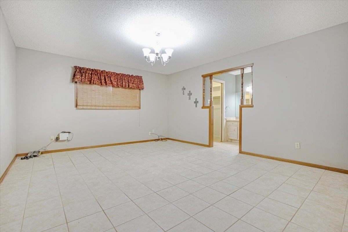 205 Smith Avenue New Home, TX 79381 - Photo 13 of 27 an empty room with chandelier fan