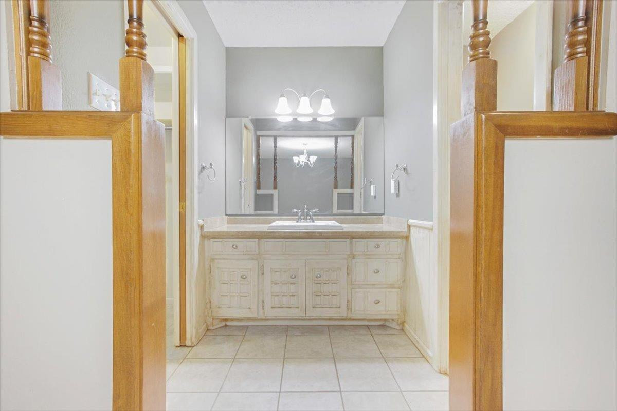 205 Smith Avenue New Home, TX 79381 - Photo 15 of 27 a bathroom with a granite countertop sink and a mirror