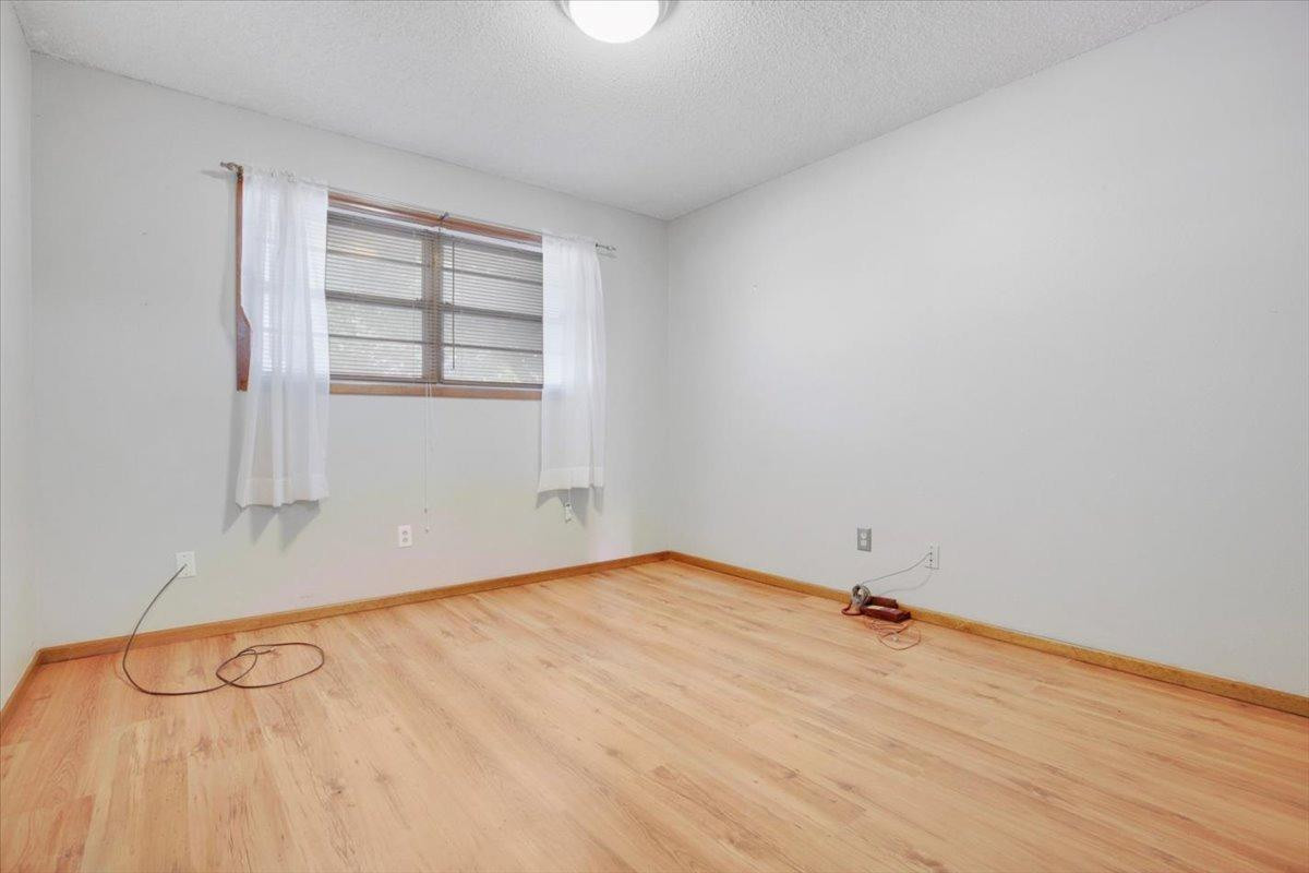 205 Smith Avenue New Home, TX 79381 - Photo 18 of 27 an empty room with wooden floor and windows