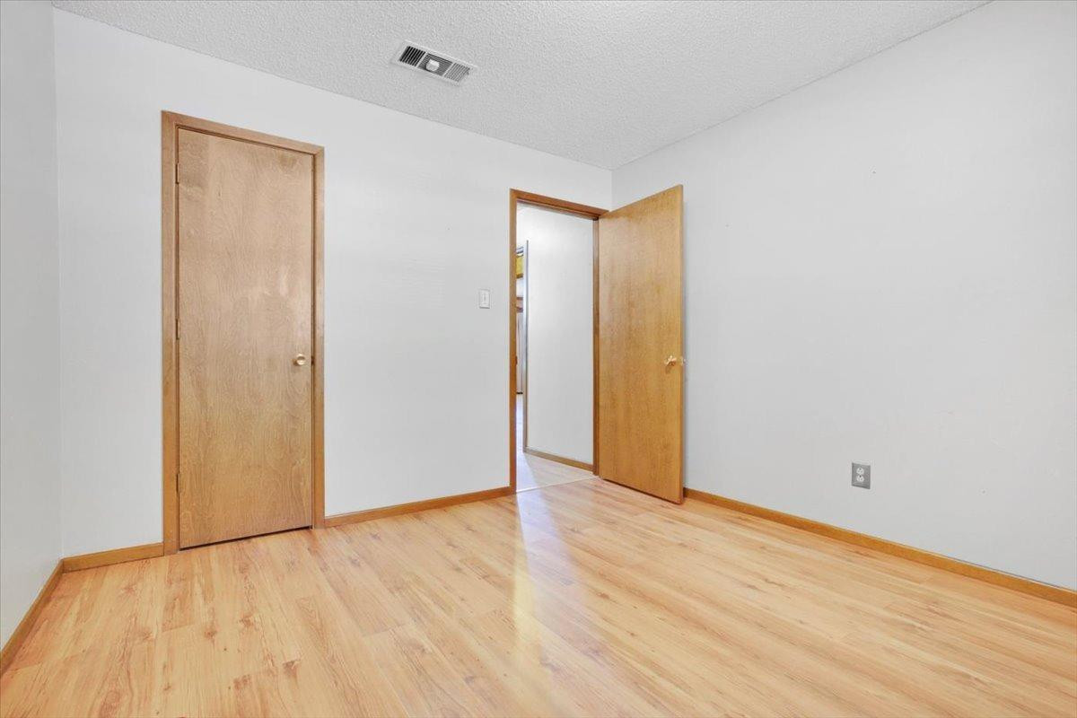 205 Smith Avenue New Home, TX 79381 - Photo 19 of 27 a view of an empty room with wooden floor
