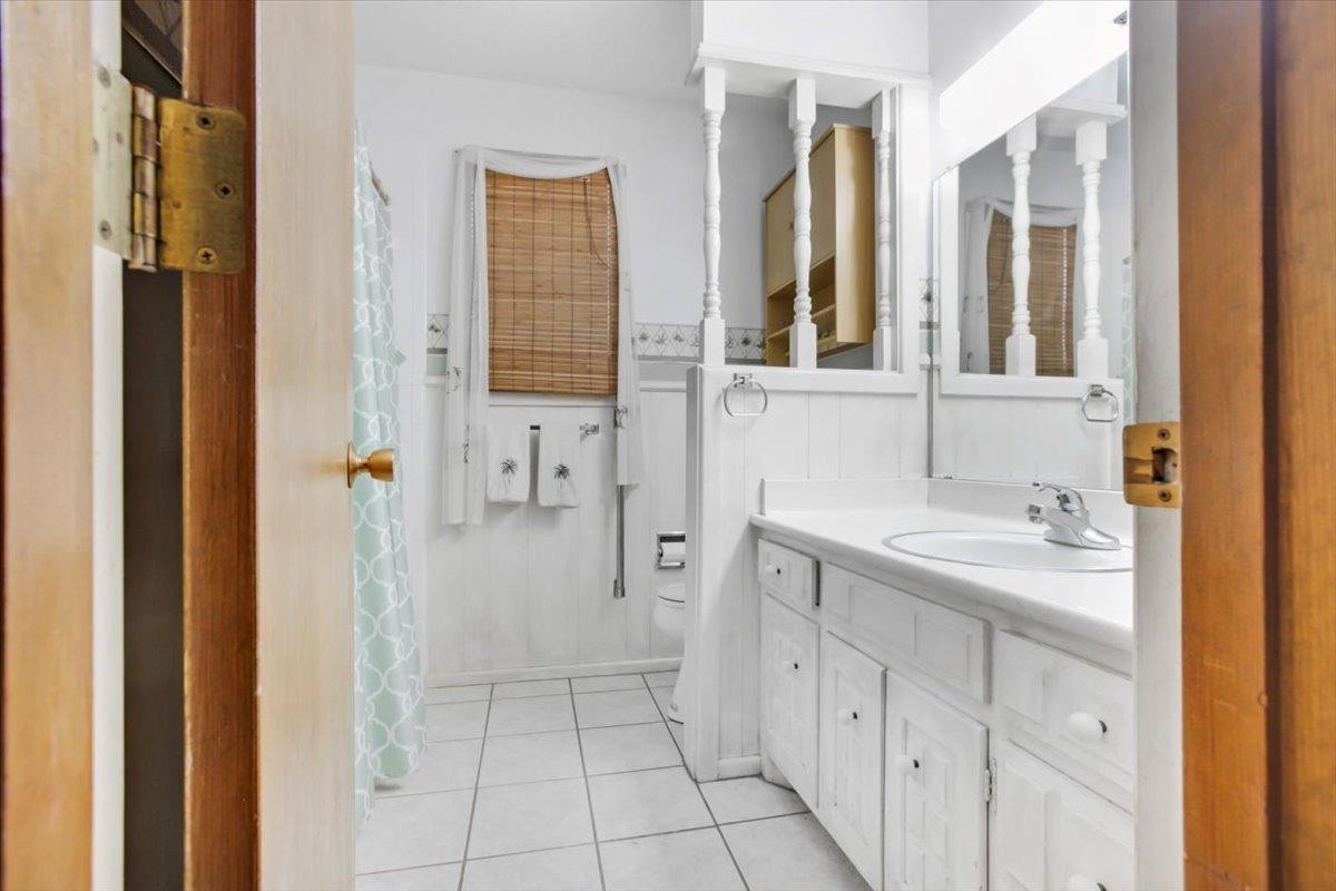 205 Smith Avenue New Home, TX 79381 - Photo 20 of 27 a spacious bathroom with a double vanity sink a mirror and a shower