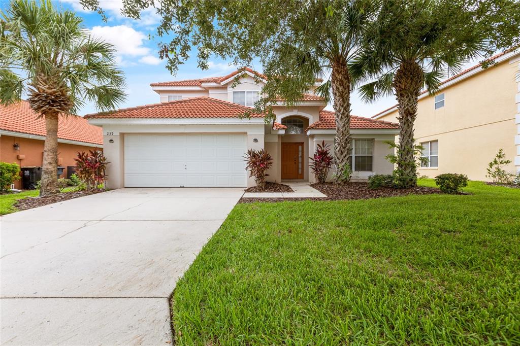 a front view of a house with a yard and trees