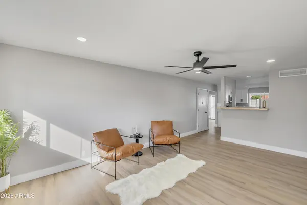 a room with stainless steel appliances kitchen island granite countertop furniture and a refrigerator