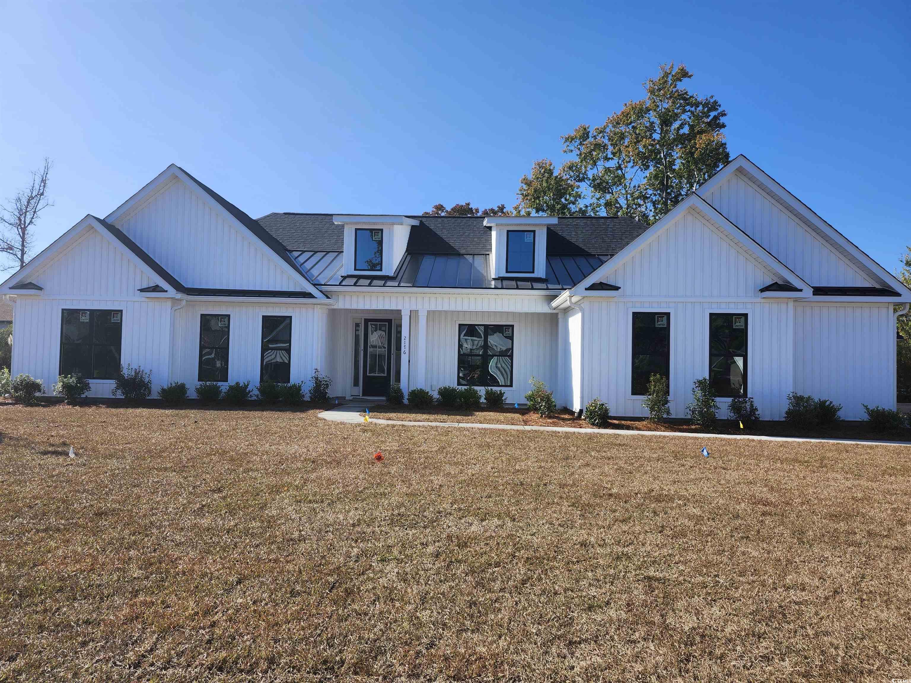 2176 Pettus Way Surfside Beach, SC 29575 - Photo 1 of 5 Modern inspired farmhouse featuring a standing seam roof, a metal roof, a front yard, and covered porch