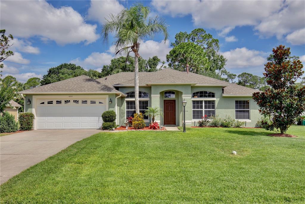 a view of a house with a yard and potted plants