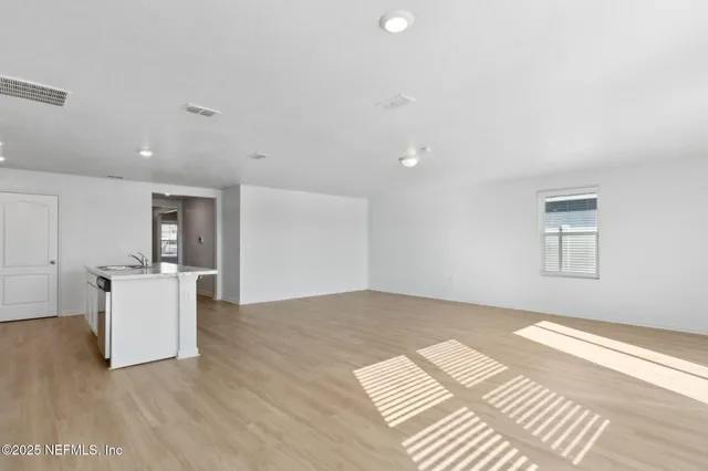 a view of a kitchen with furniture and wooden floor