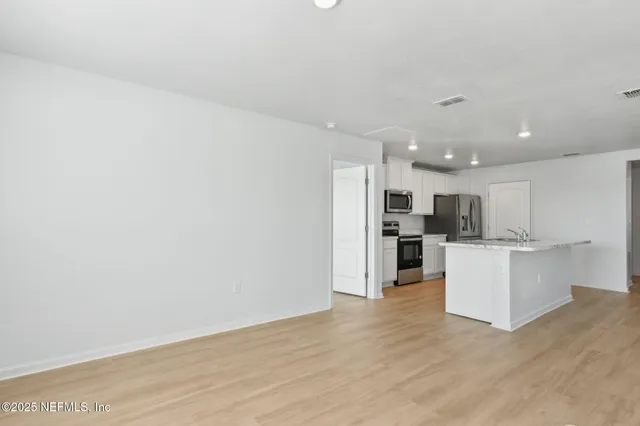 a view of kitchen with stainless steel appliances cabinets and wooden floor