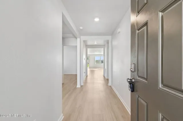 a view of a hallway with wooden floor