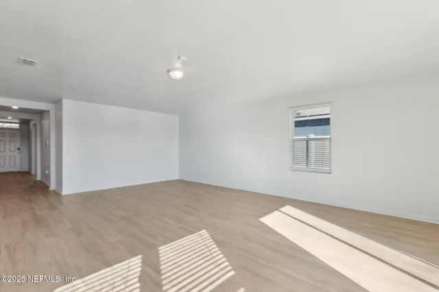 a view of empty room with wooden floor