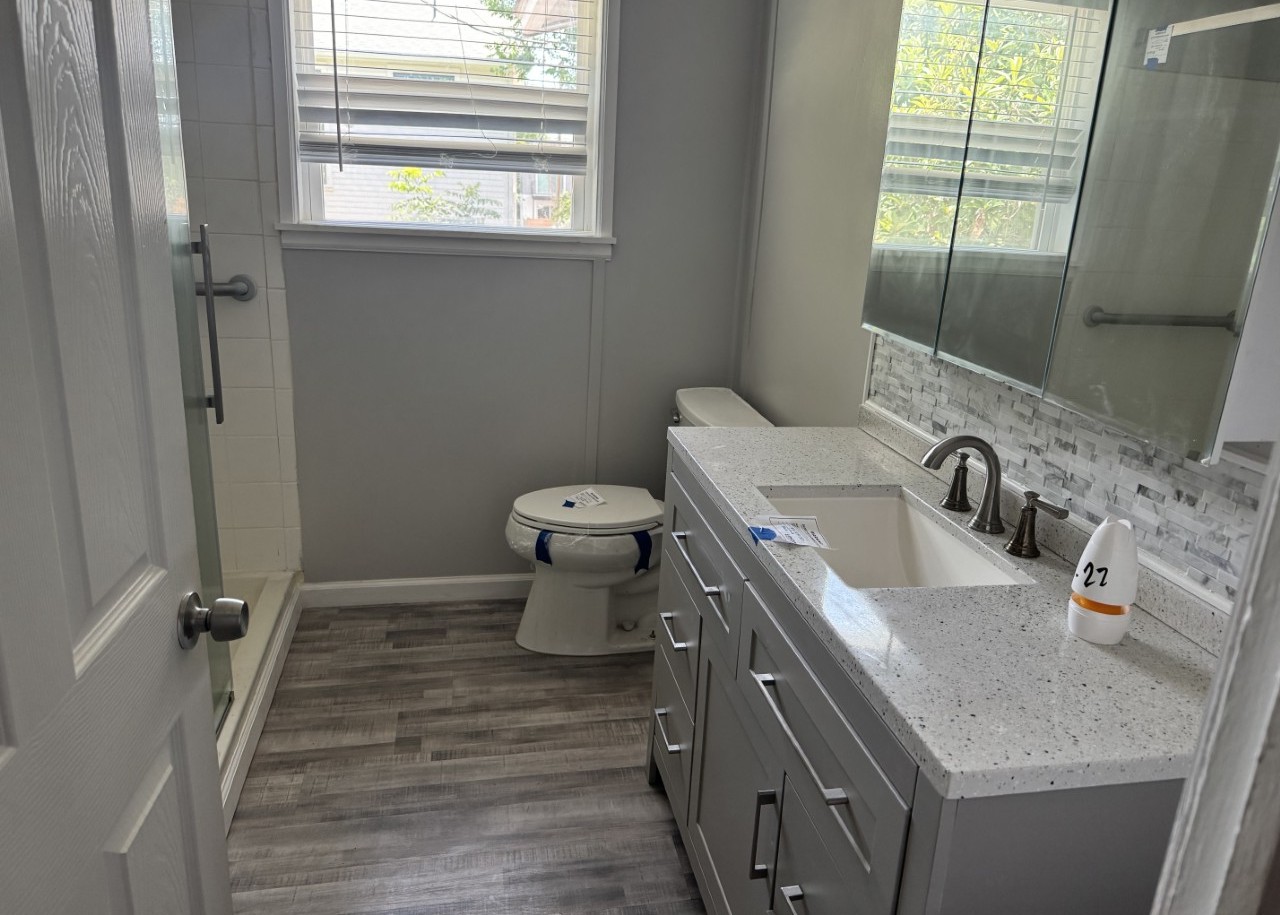 1813 Rhodes Road Austin, TX 78721 - Photo 9 of 14 A well-appointed bathroom features a contemporary vanity and stylish gray plank flooring.