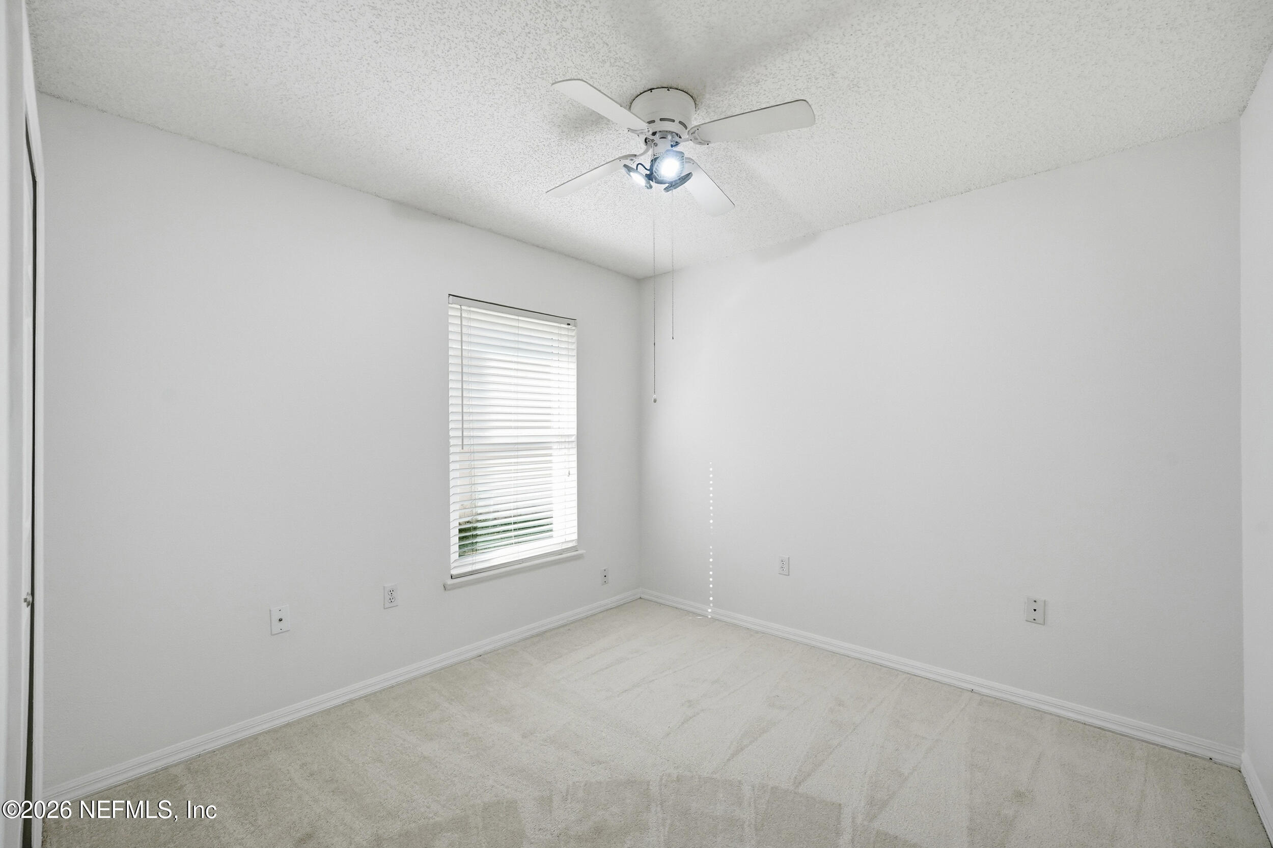 3380 Net Court Jacksonville, FL 32277 - Photo 17 of 20 an empty room with a ceiling fan and windows