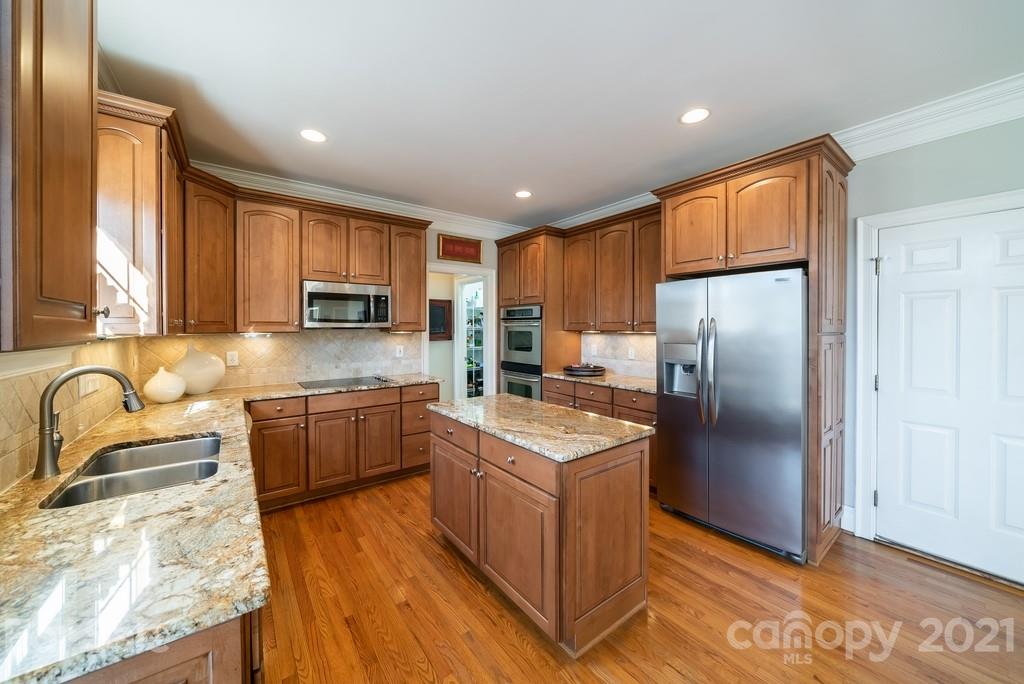 268 Hemmingway Lane Fort Mill, SC 29708 - Photo 14 of 43 a kitchen with stainless steel appliances granite countertop a refrigerator a sink dishwasher a stove with wooden cabinets and floor