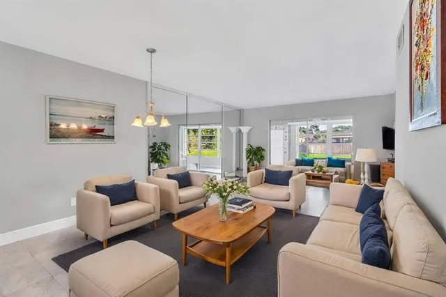 a living room with furniture a chandelier and a window