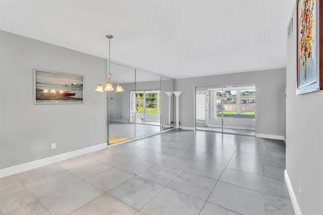 a view of an empty room with window and cabinet area